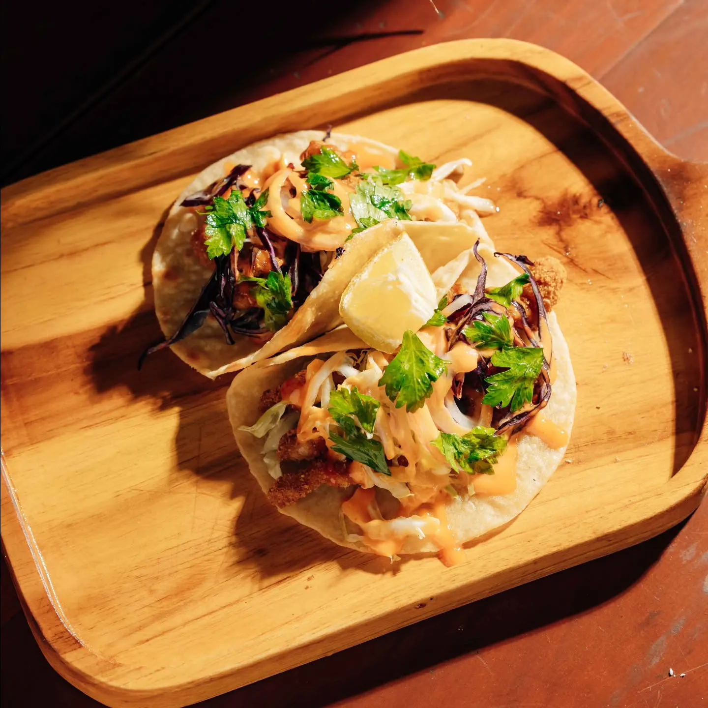 Tacos on a wooden board from the wood-fired kitchen